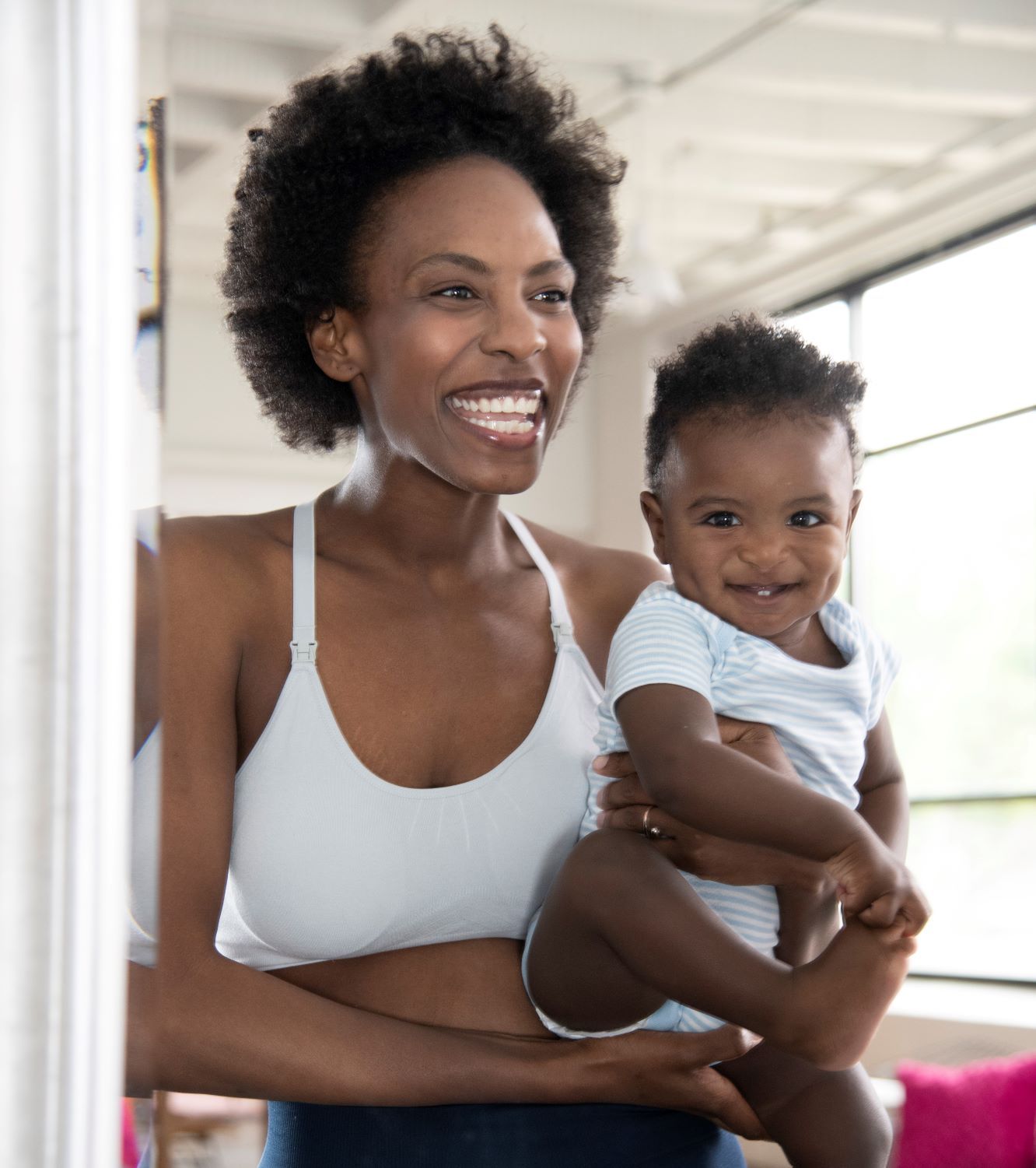 Woman wearing gray nursing bra holding a baby