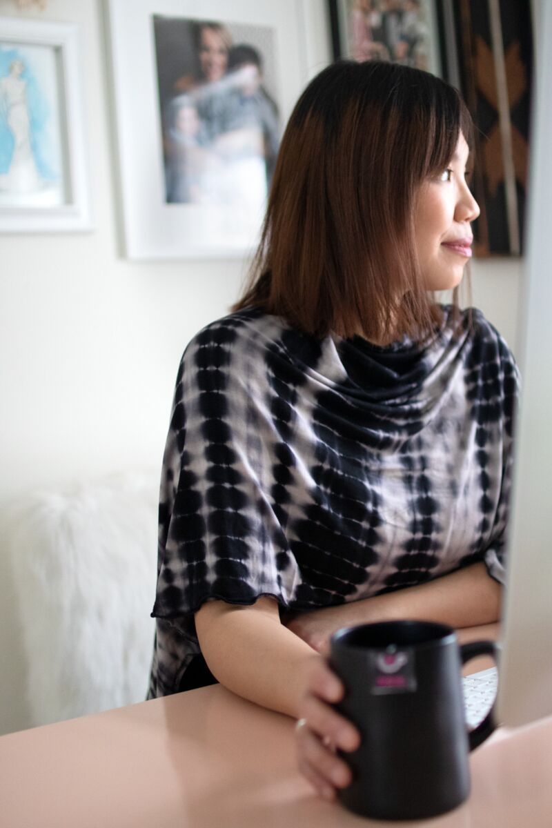 Woman wearing shibori open nursing cover drinking tea