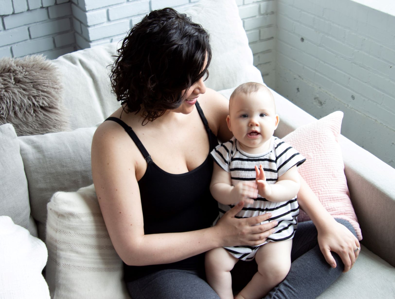 Woman wearing black seamless nursing tank top holding a baby