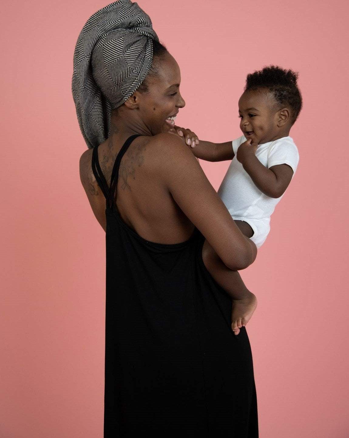 Back of woman wearing black nursing nightgown holding her baby