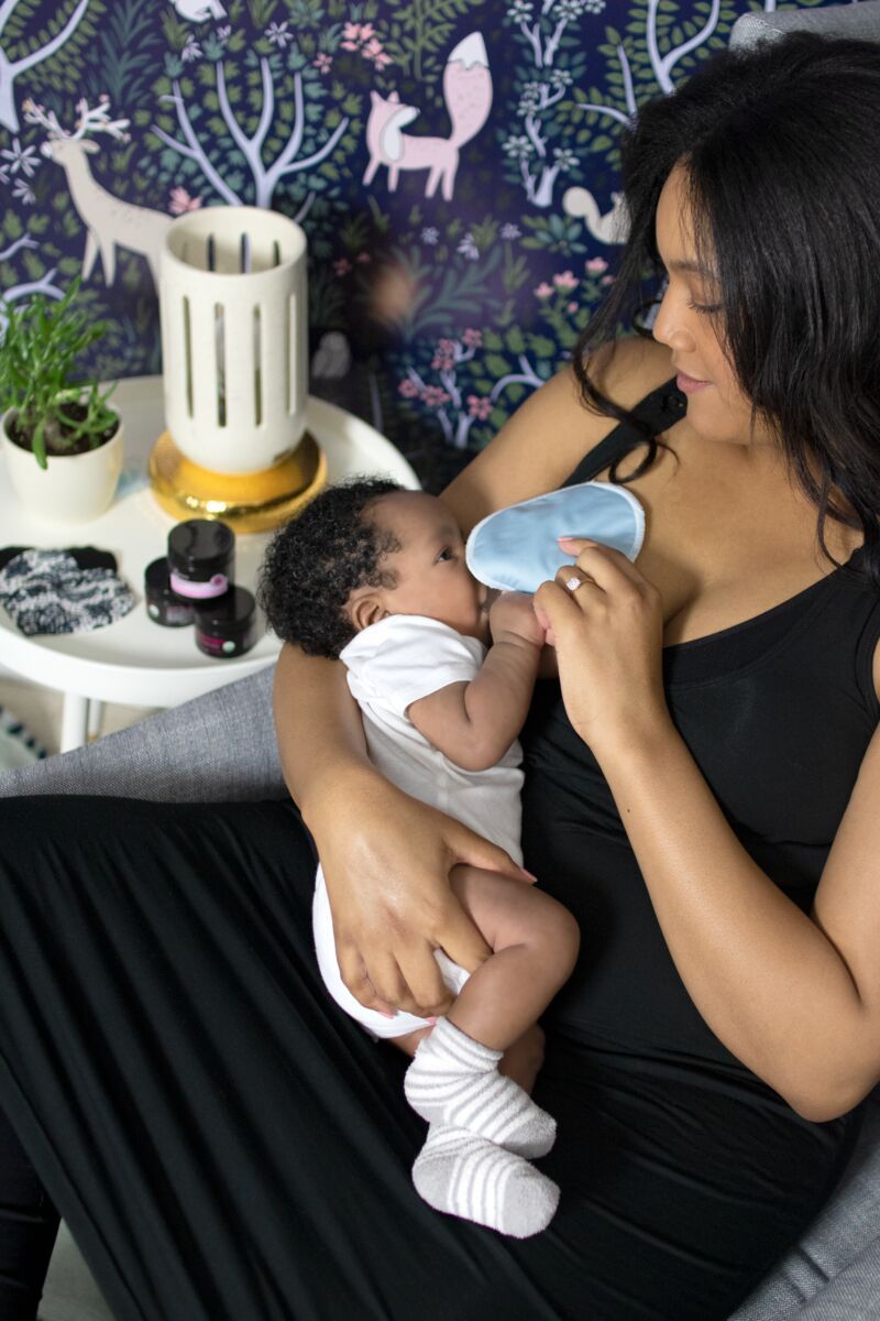 Woman breastfeeding her baby wearing black nursing nightgown